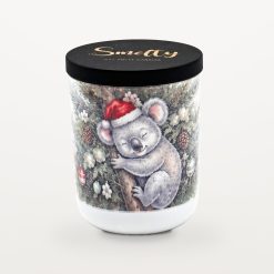 Smelty Christmas candle in a white ceramic jar with a black wooden lid and gold Smelty logo, printed with a sleepy koala in a Santa hat hugging the trunk inside a Christmas tree decorated with pine cones and baubles.